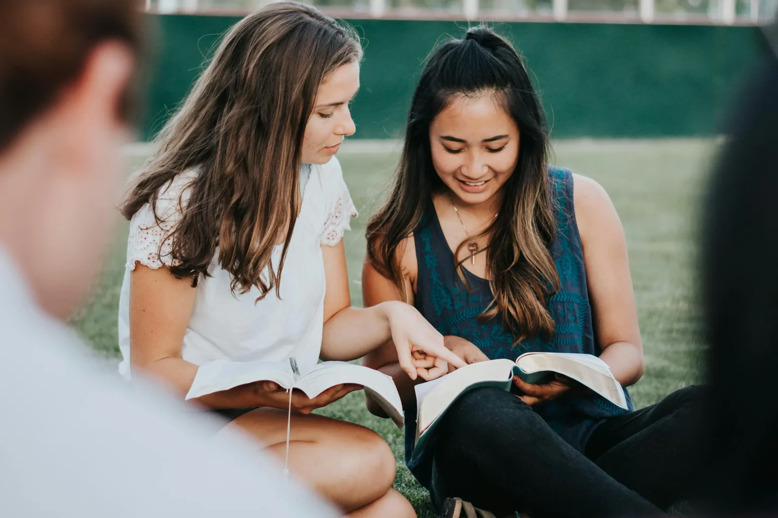 Jóvenes conversando y compartiendo en comunidad alrededor de una Biblia
